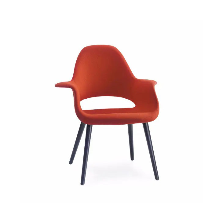 Sedia Organic di Vitra rosso mattone con struttura nera su fondo bianco. 