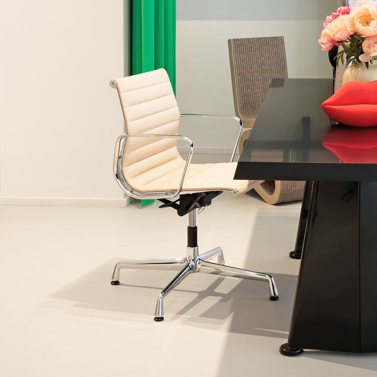 Vitra Aluminum Chair con seduta bianco crema e base cromata, in showroom SAG'80 Selection.