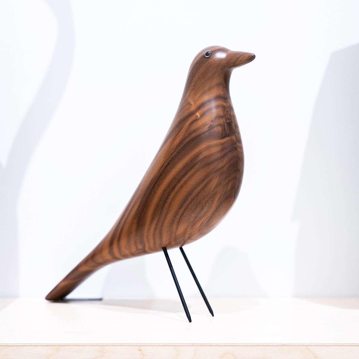 Vitra Eames Bird in legno, poggiato su mensola in showroom SAG'80 Selection.