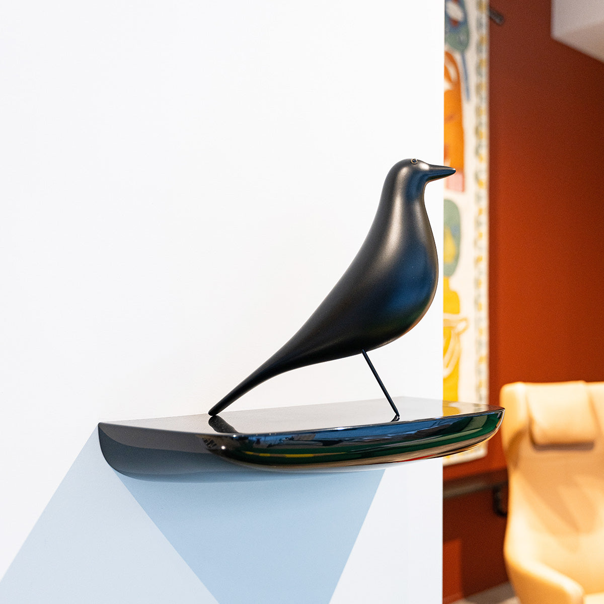 Vitra Eames bird nero su piccola mensola laccata in showroom SAG'80 Selection.