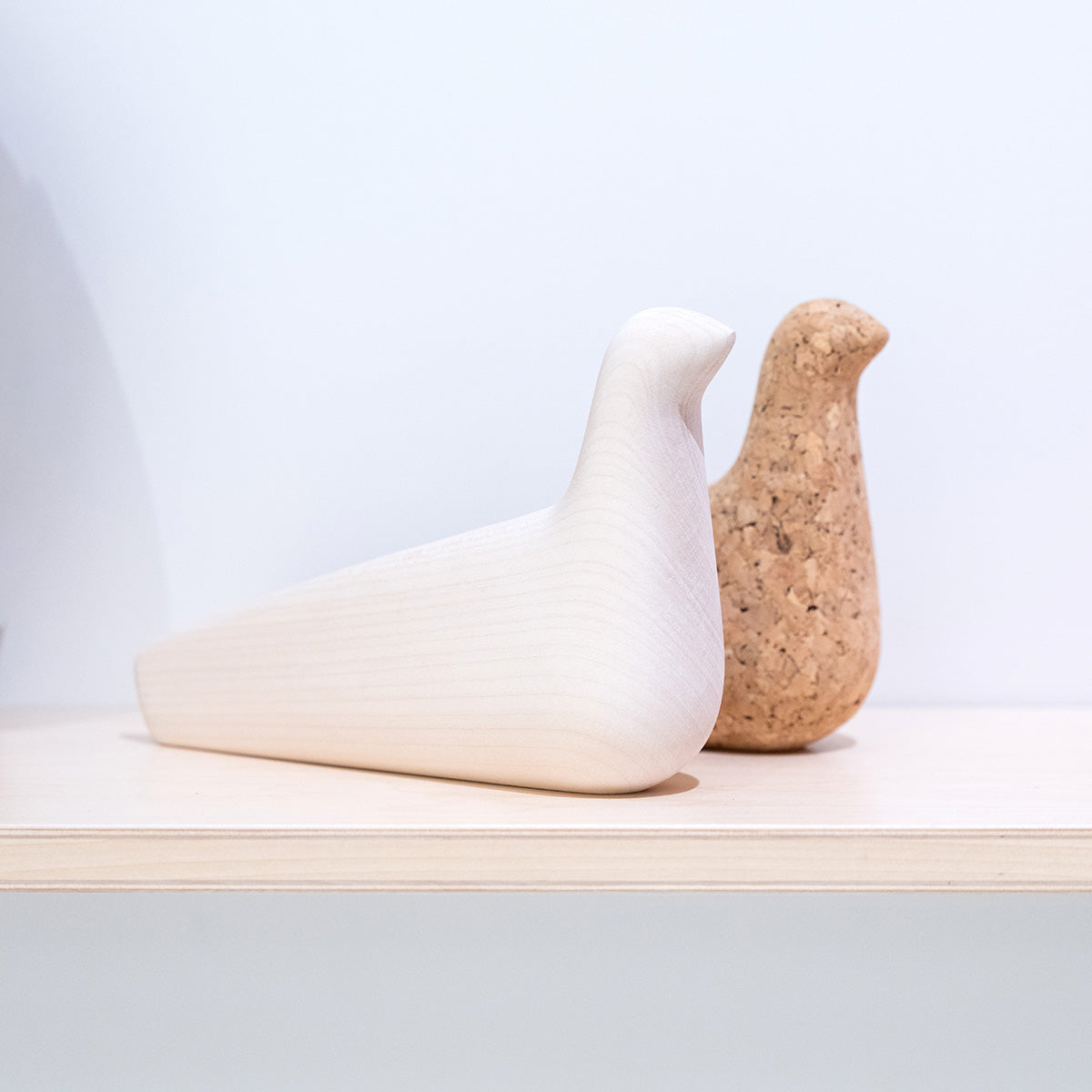 Due statue Vitra L'Oiseau su mensola in legno in showroom SAG'80 Selection.