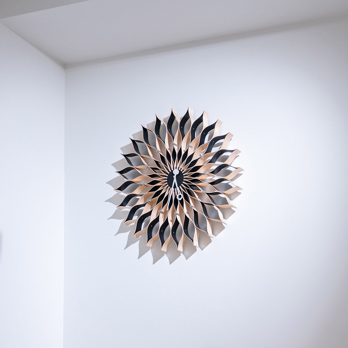 Vitra Sunflower Clock appeso a parete bianca in showroom SAG'80 Selection.