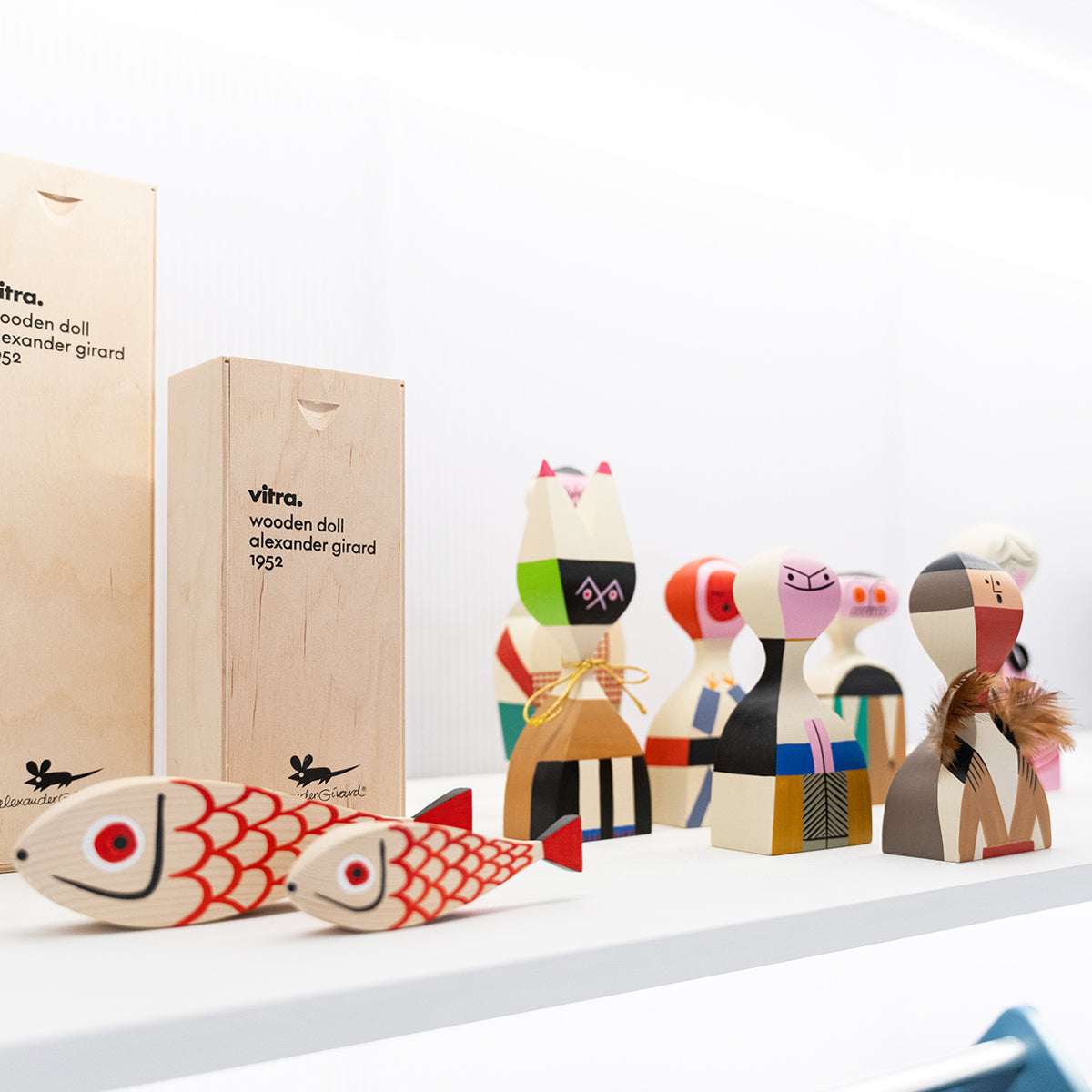 Vitra Wooden Dolls in varie dimensioni e finiture, su mensola bianca con fondo bianco. 